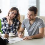 Young couple signs personal loan contract with banker