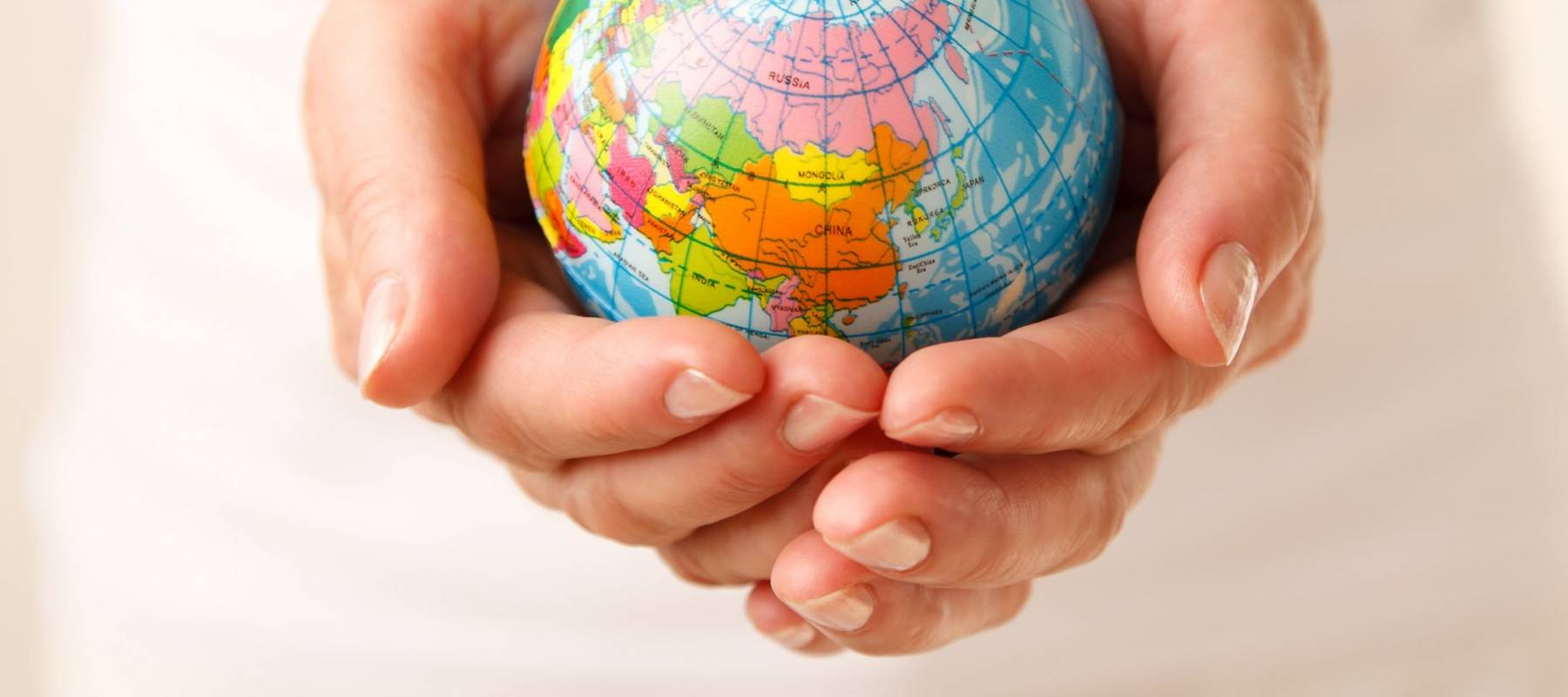 Young woman holding a globe in his hands.