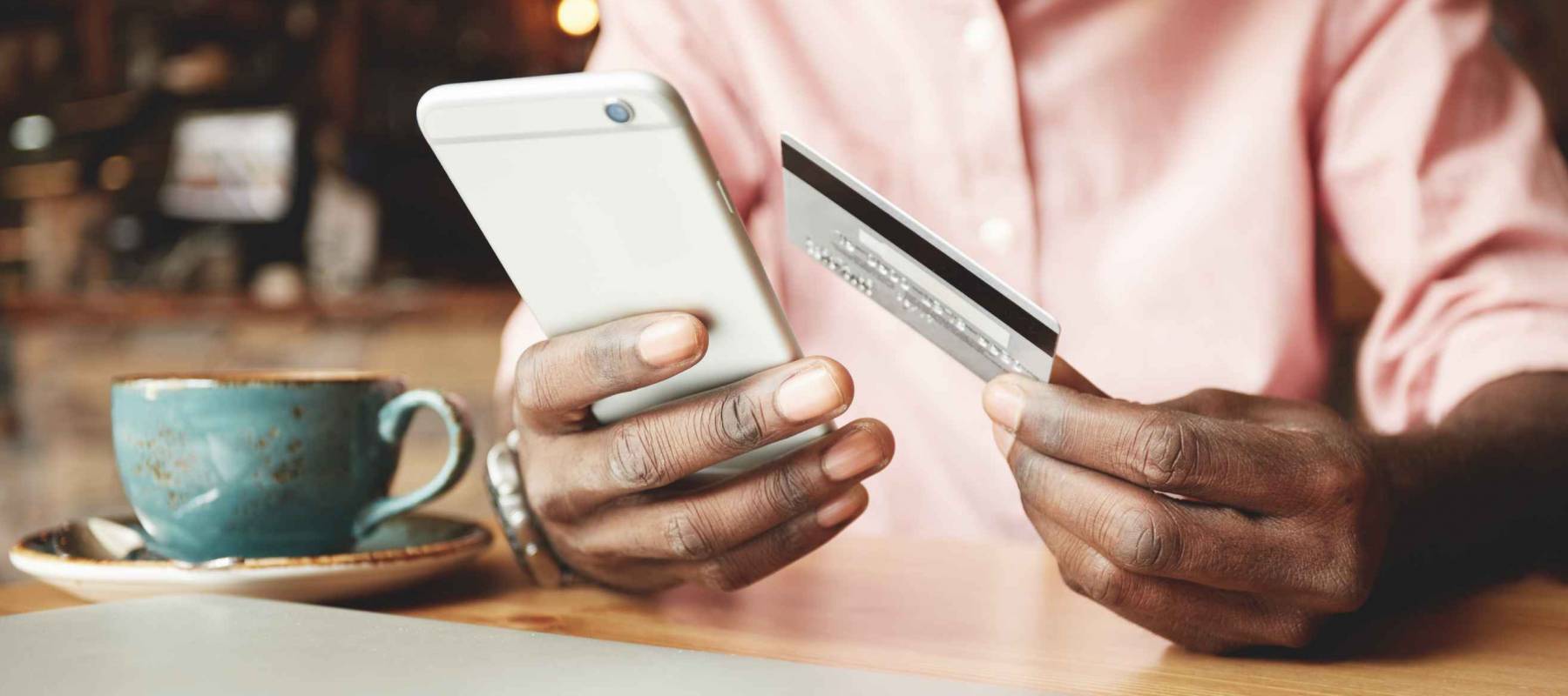 Man in casual shirt banking online using mobile phone.
