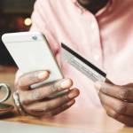 Man in casual shirt banking online using mobile phone.
