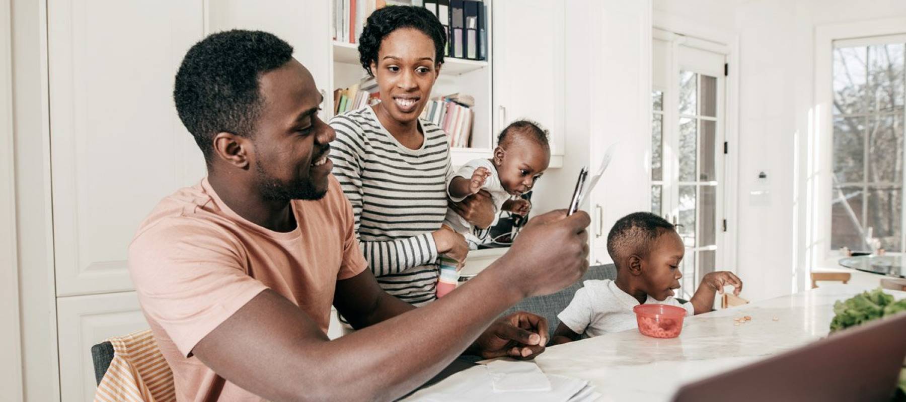 African-American couple with two children working on their finances at their dining table