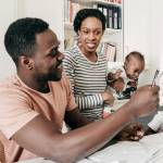 African-American couple with two children working on their finances at their dining table