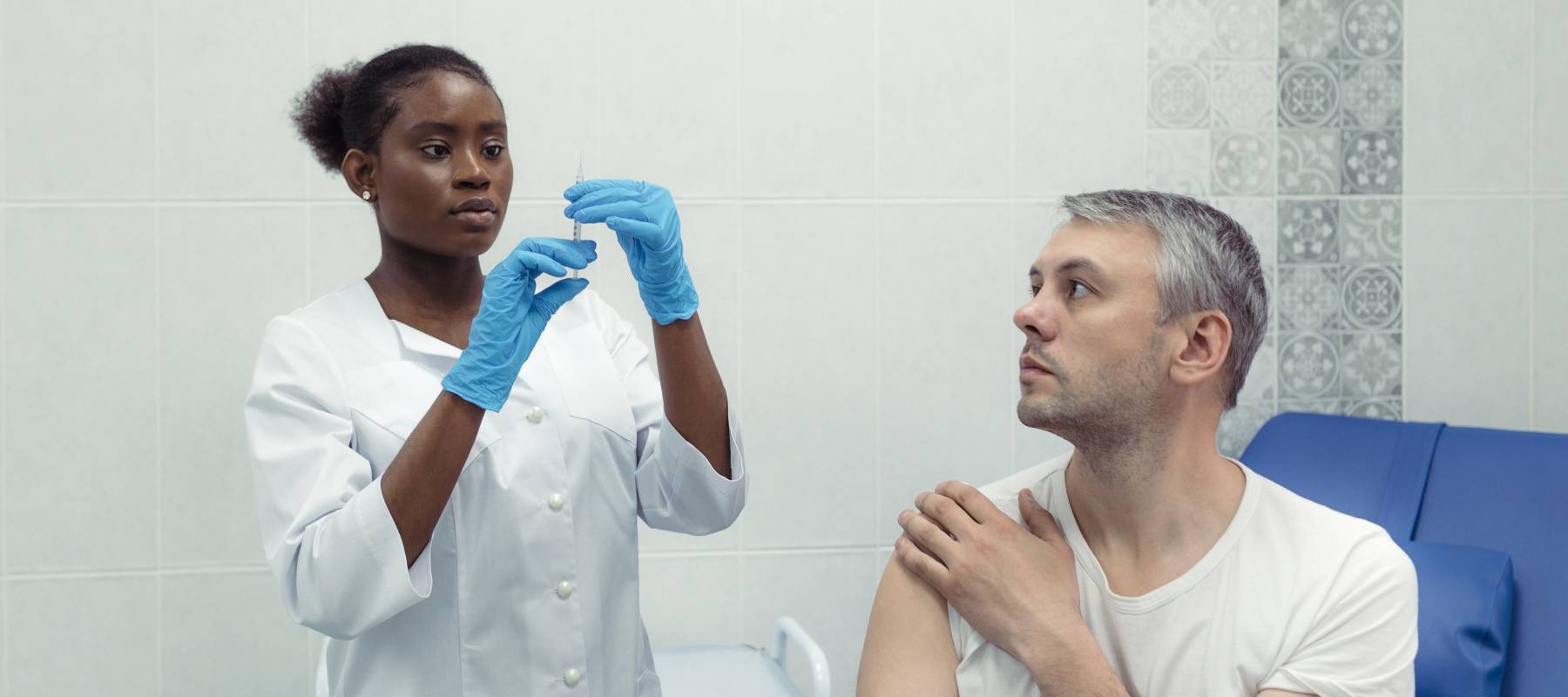 Nurse holds a syringe ready to give a patient a shot.