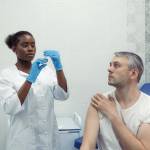 Nurse holds a syringe ready to give a patient a shot.