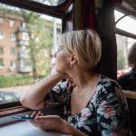 Middle-aged woman looking out of a train window, deep in thought.