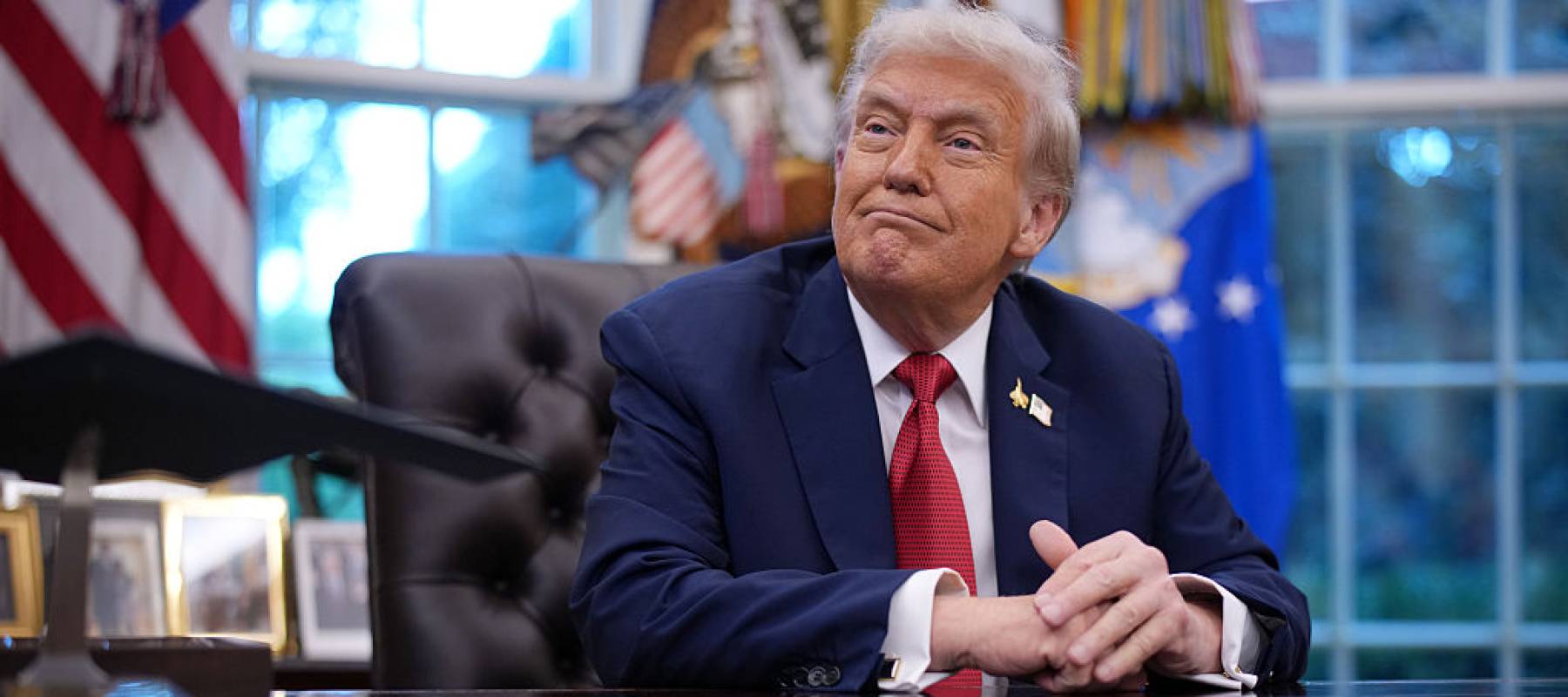 President Donald Trump sitting at his desk in the Oval Office.
