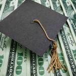 graduation cap on assorted hundred dollar bills - education concept