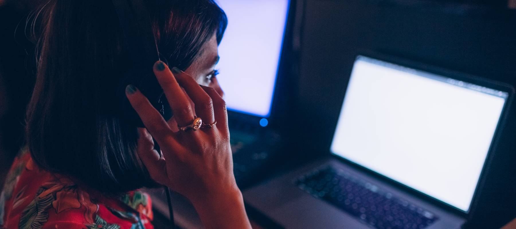 Woman looking concerned while staring at computer screen.
