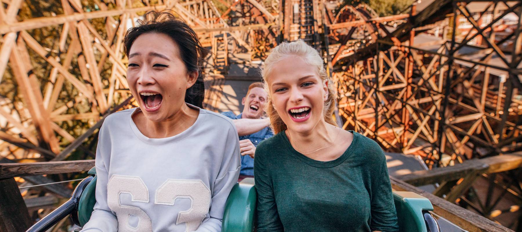 Young friends ride a rollercoaster together.