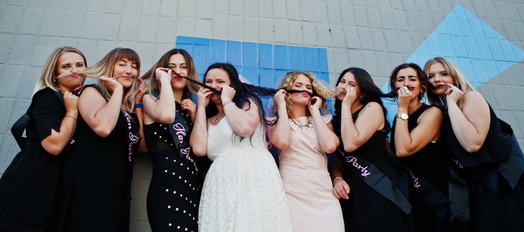A bride and her bridesmaids pose for a photo.