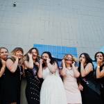A bride and her bridesmaids pose for a photo.