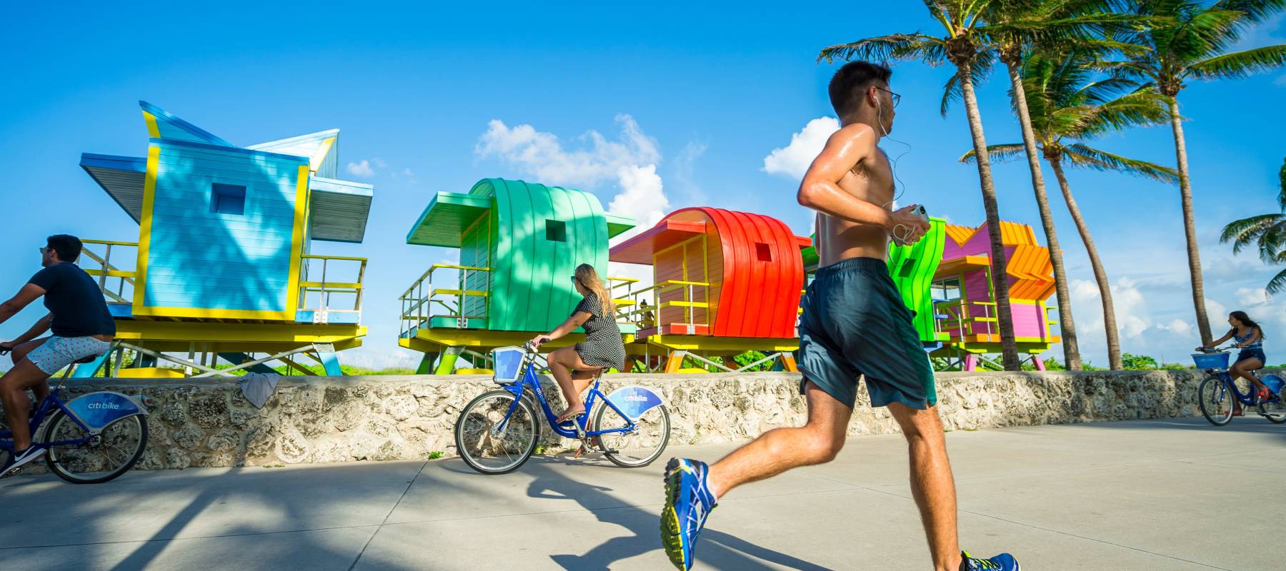 People ride bicycles and jog along the Miami Beach promenade.