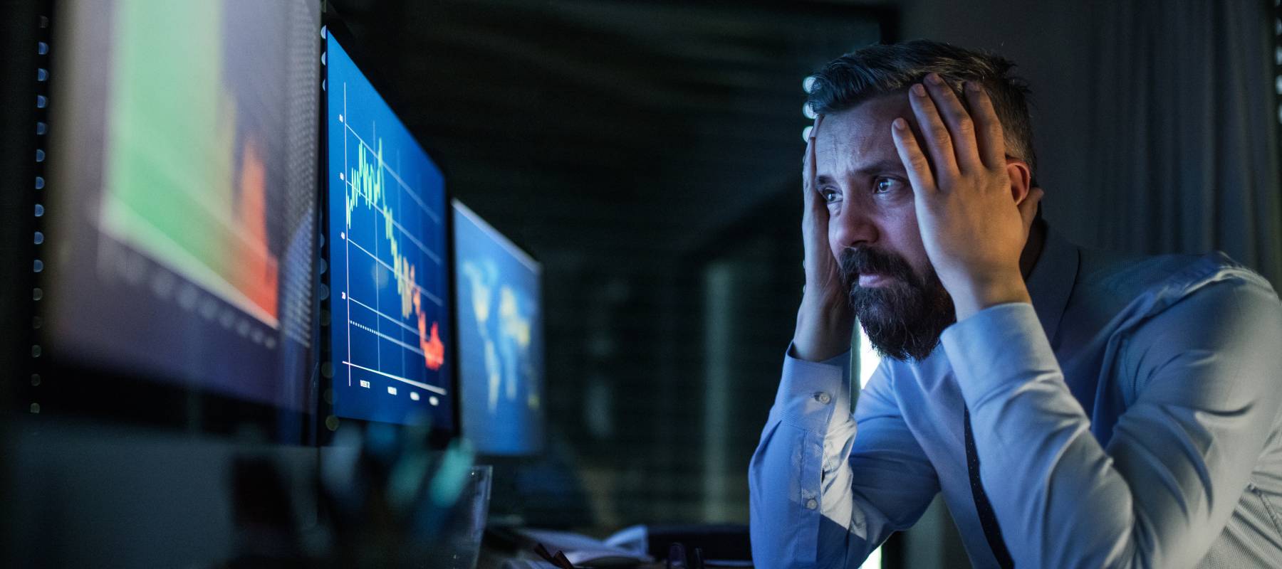 Man holding his hands by computer screen.