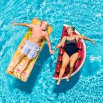 Senior couple on floating rafts in a swimming pool