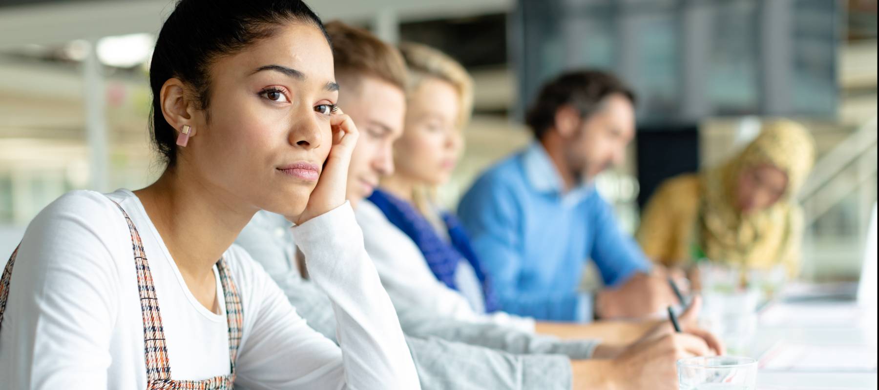 Thoughtful woman contemplating things at a board meeting.