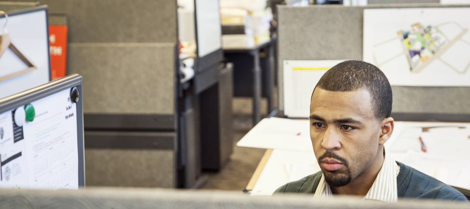 Black man working in his cubicle in an corporate office
