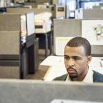 Black man working in his cubicle in an corporate office