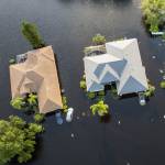 Aerial view of flooded homes and cars in a neighborhood after Hurricane Debby.