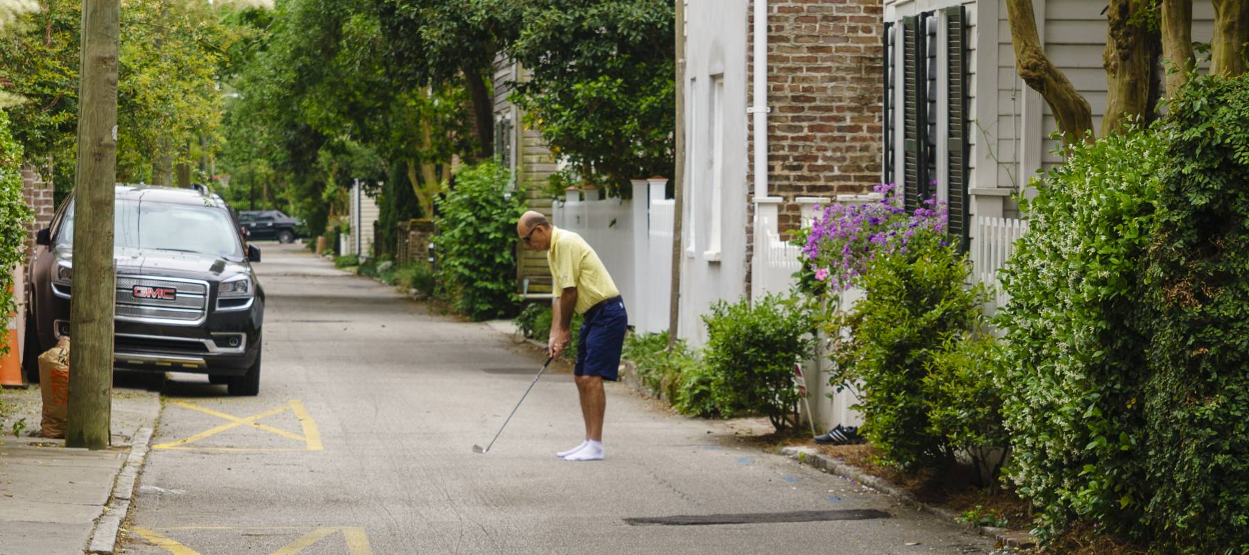 Mature man plays golf on the street in Charleston, South Carolina.