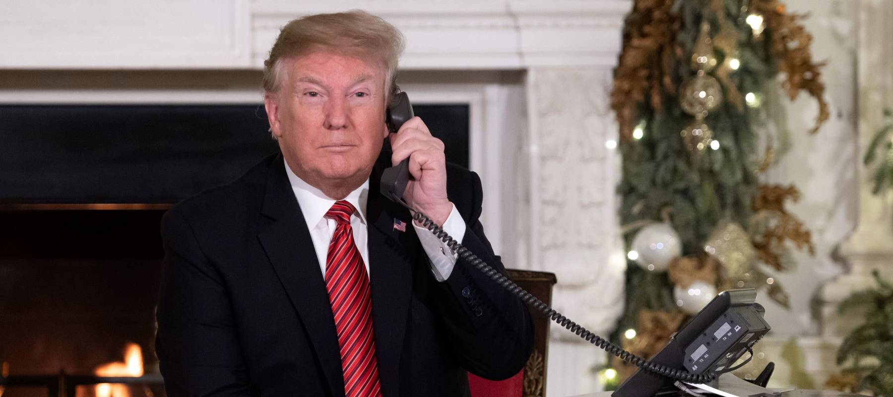US President Donald Trump speaks on the telephone as he answers calls at Christmas in 2018.