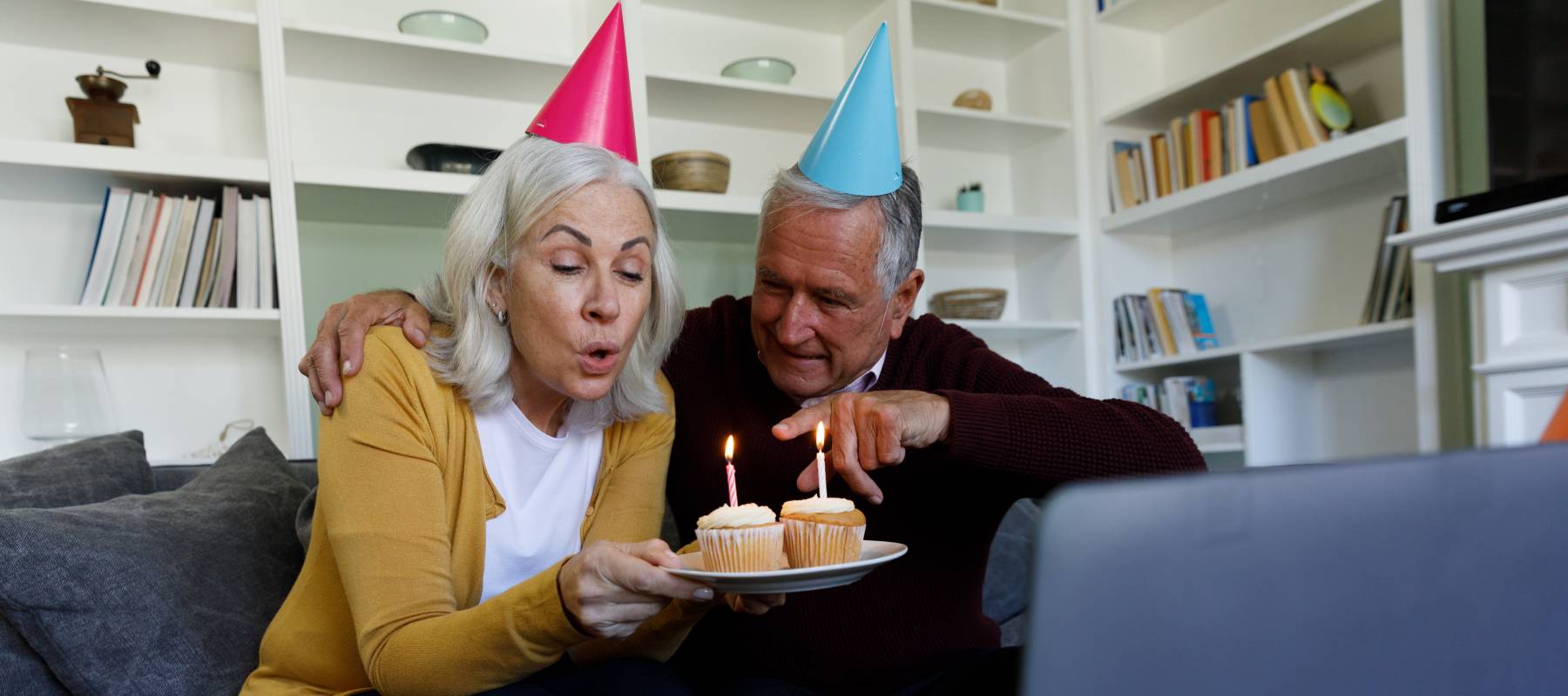 Senior caucasian couple celebrating birthday while having a video chat on laptop at home