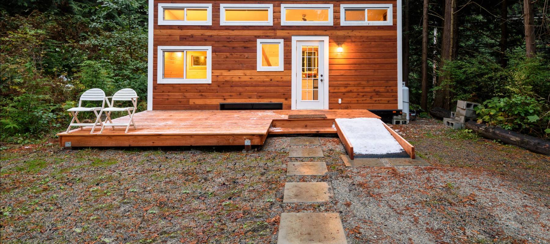 Small wooden cabin house in the evening. Exterior design.