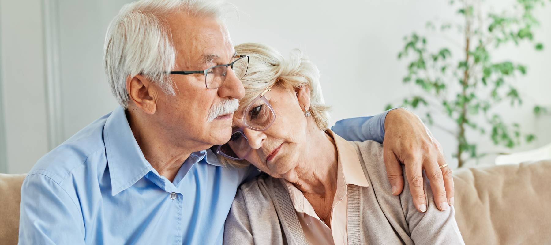 Caucasian senior couple looking worried on the couch