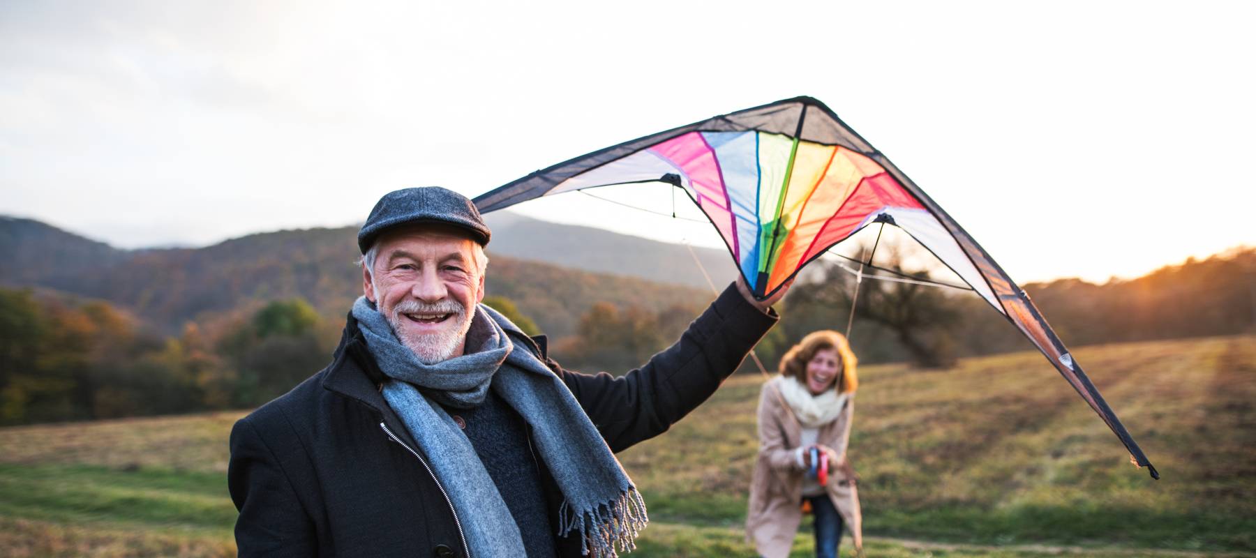 Caucasian senior couple laughing outdoors as they try to fly a kite