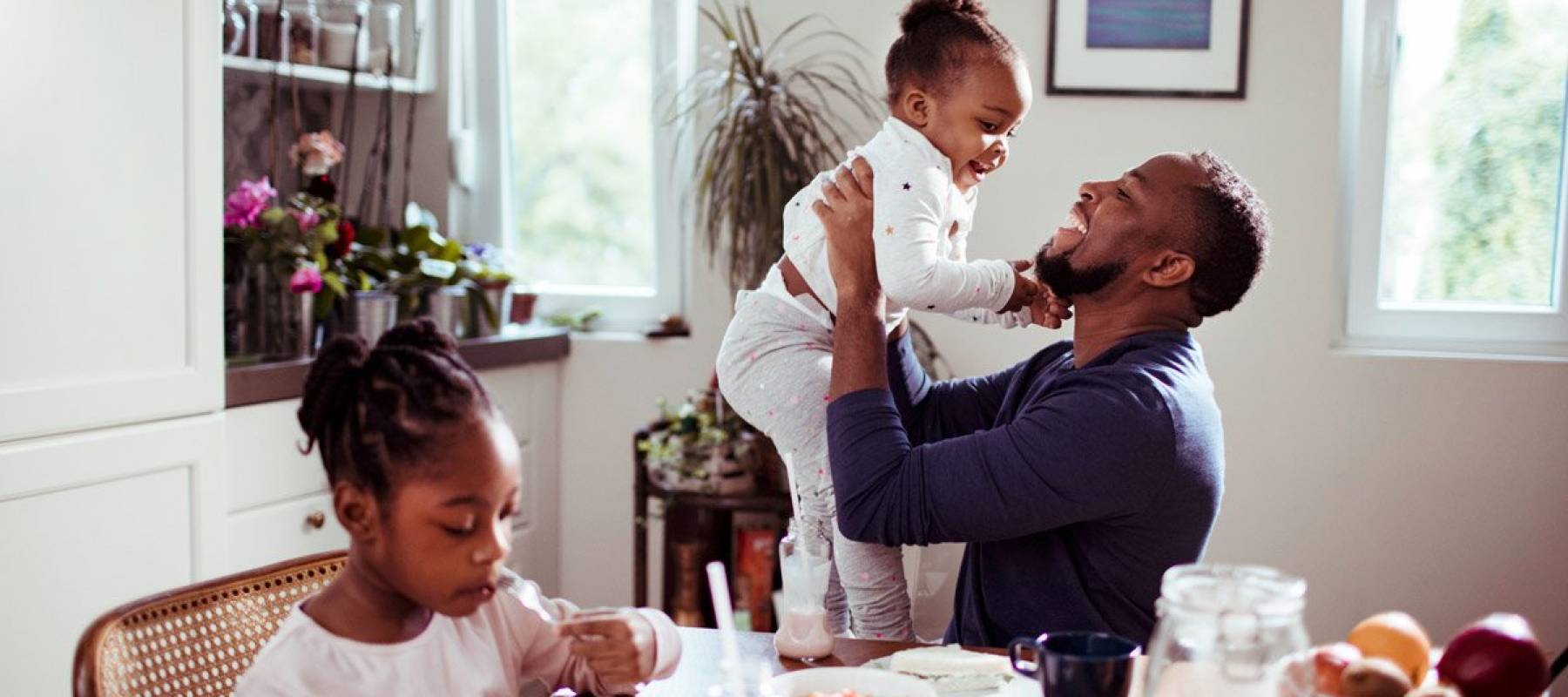 Father at the breakfast table with his two daughters