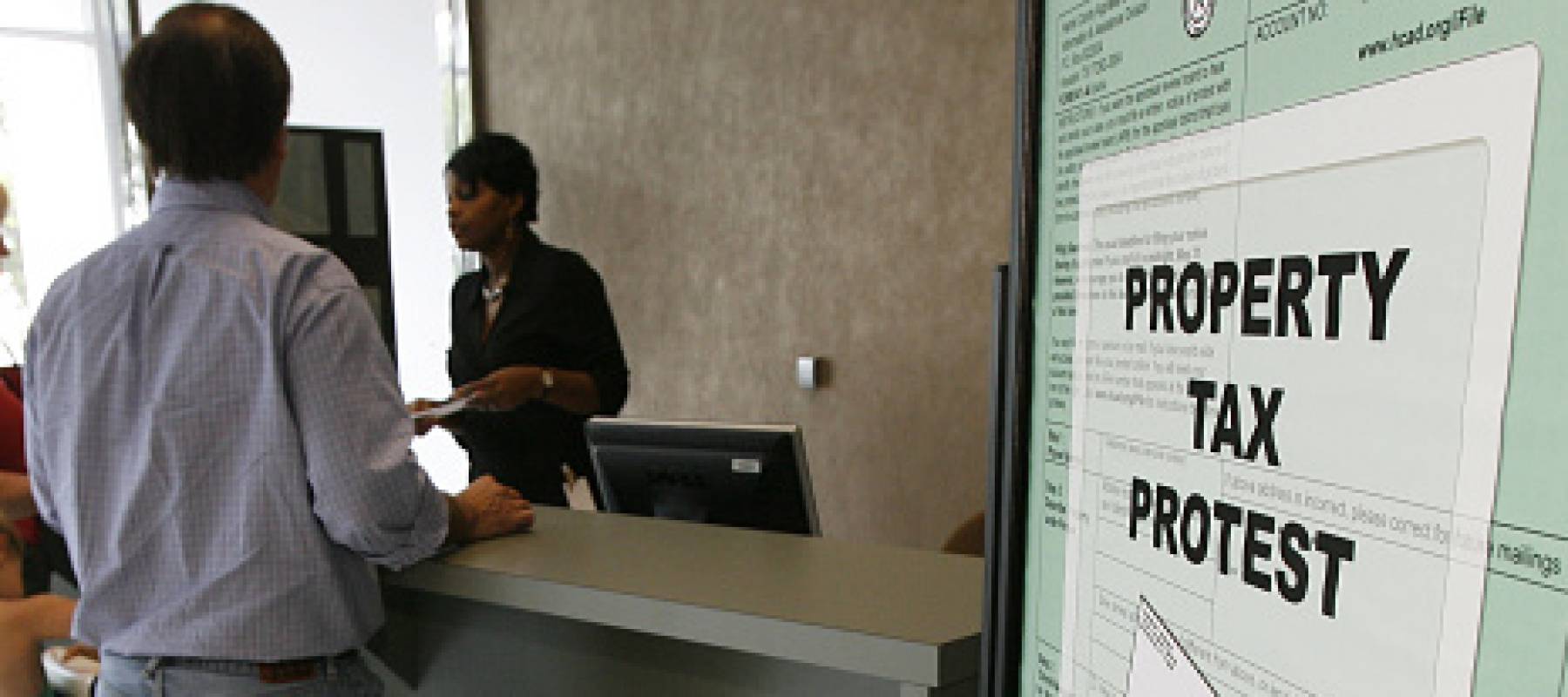 People in line at a property tax protest drop-off counter.