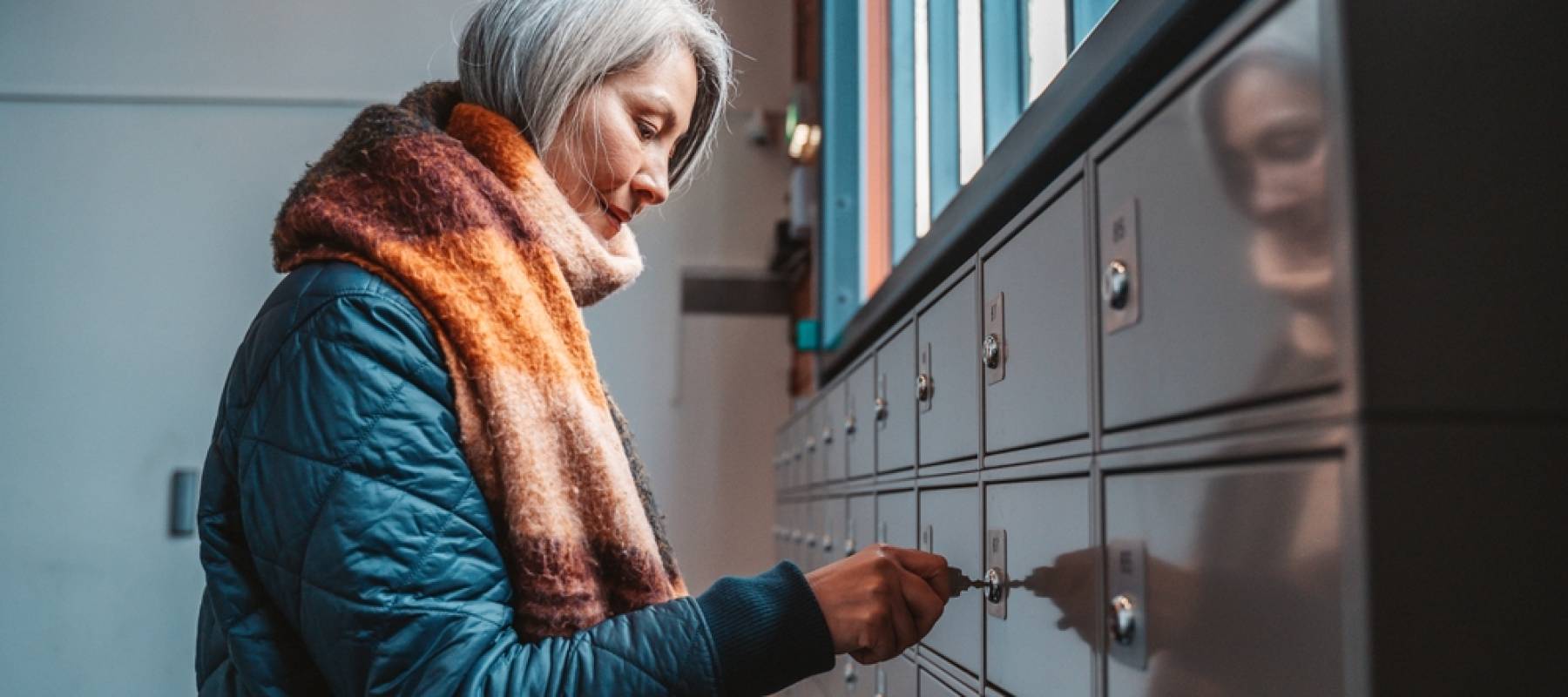 A woman opening her mailbox.