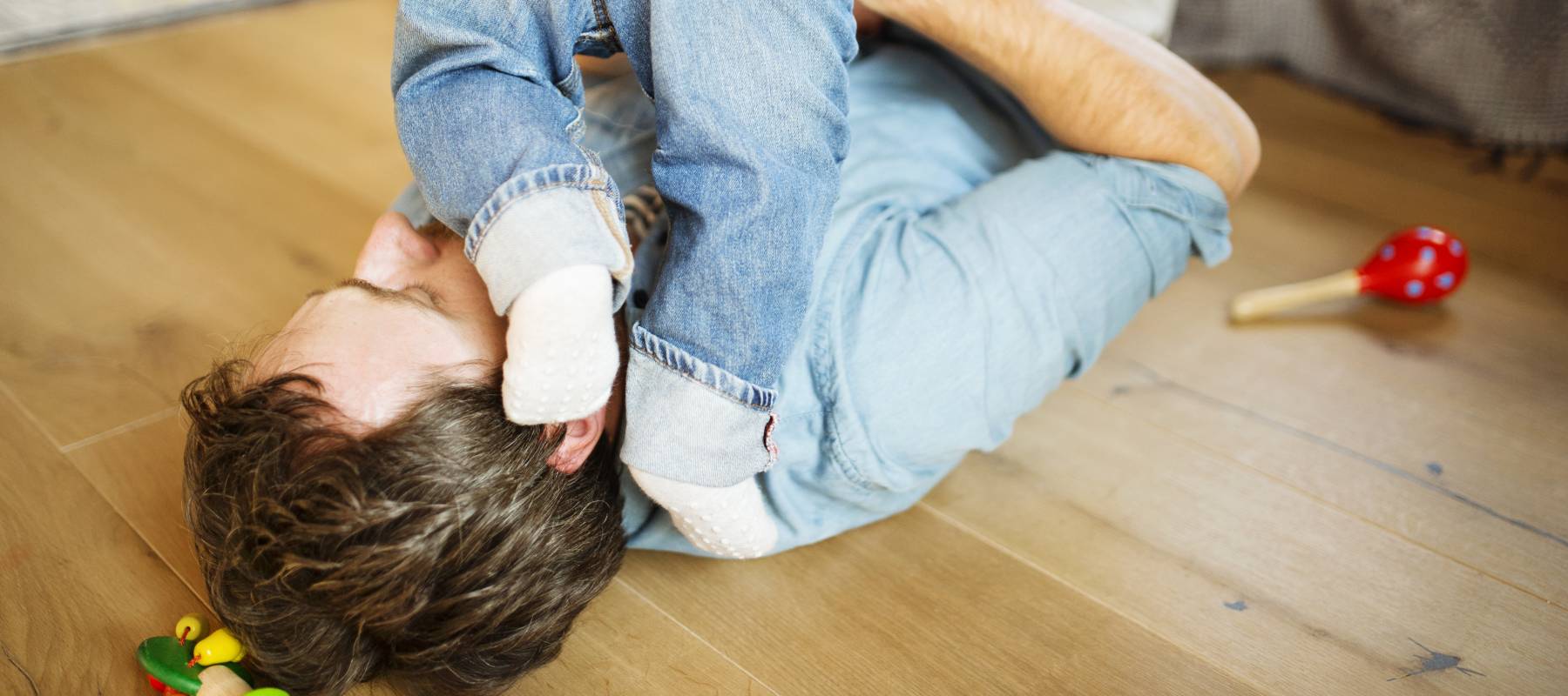 Young father at home playing with his little son.