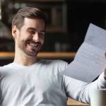 Excited job applicant reading generous job offer letter.