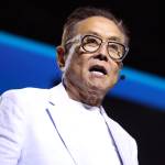 A collage image of Robert Kiyosaki speaking in a white suit and Warren Buffett in a suit scratching at his head.