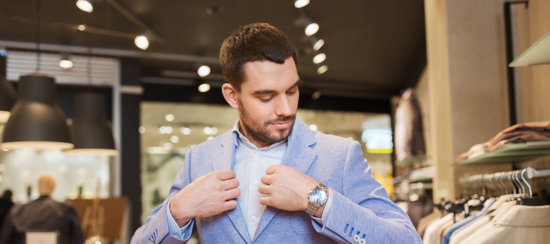 a Caucasian man in his 20s trying on an expensive suit