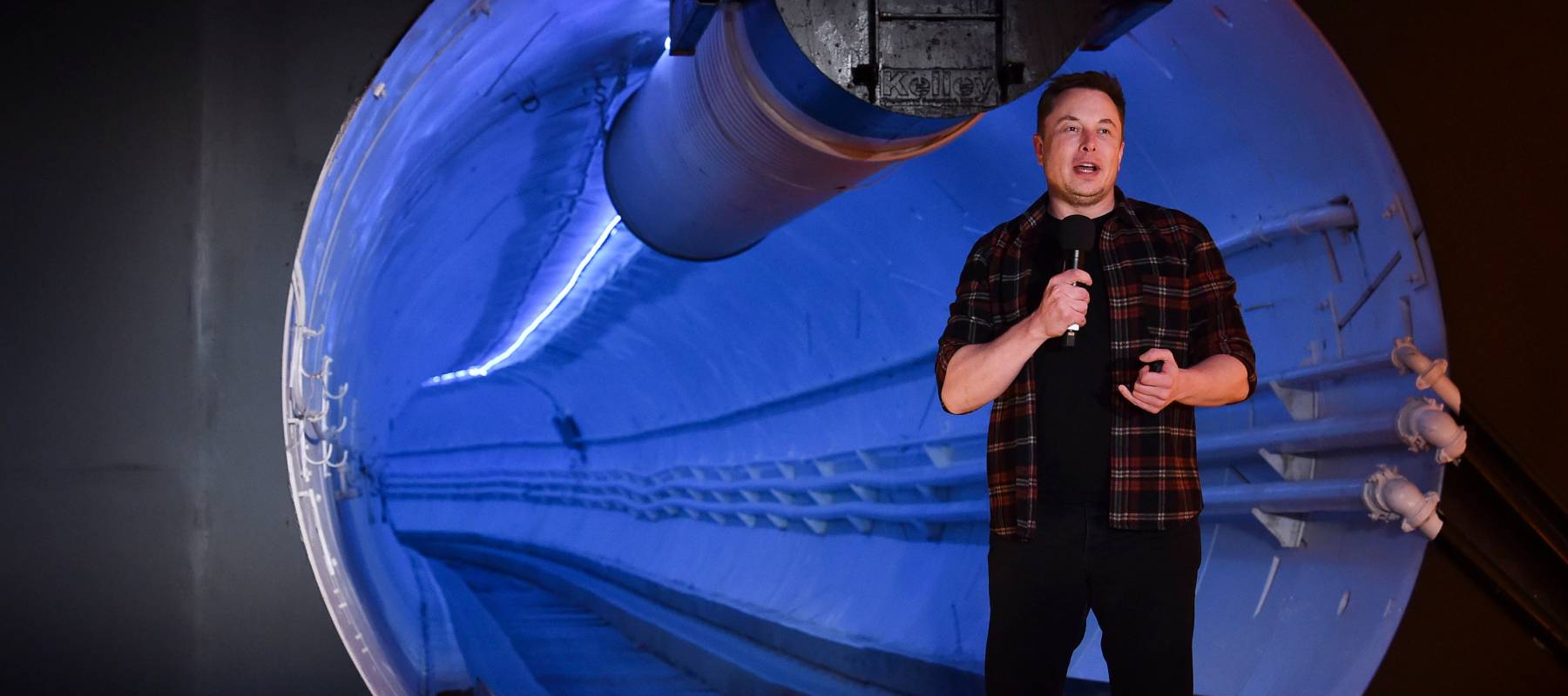 Elon Musk speaks in front of an underground tunnel at an unveiling for the Boring Company Hawthorne test tunnel.