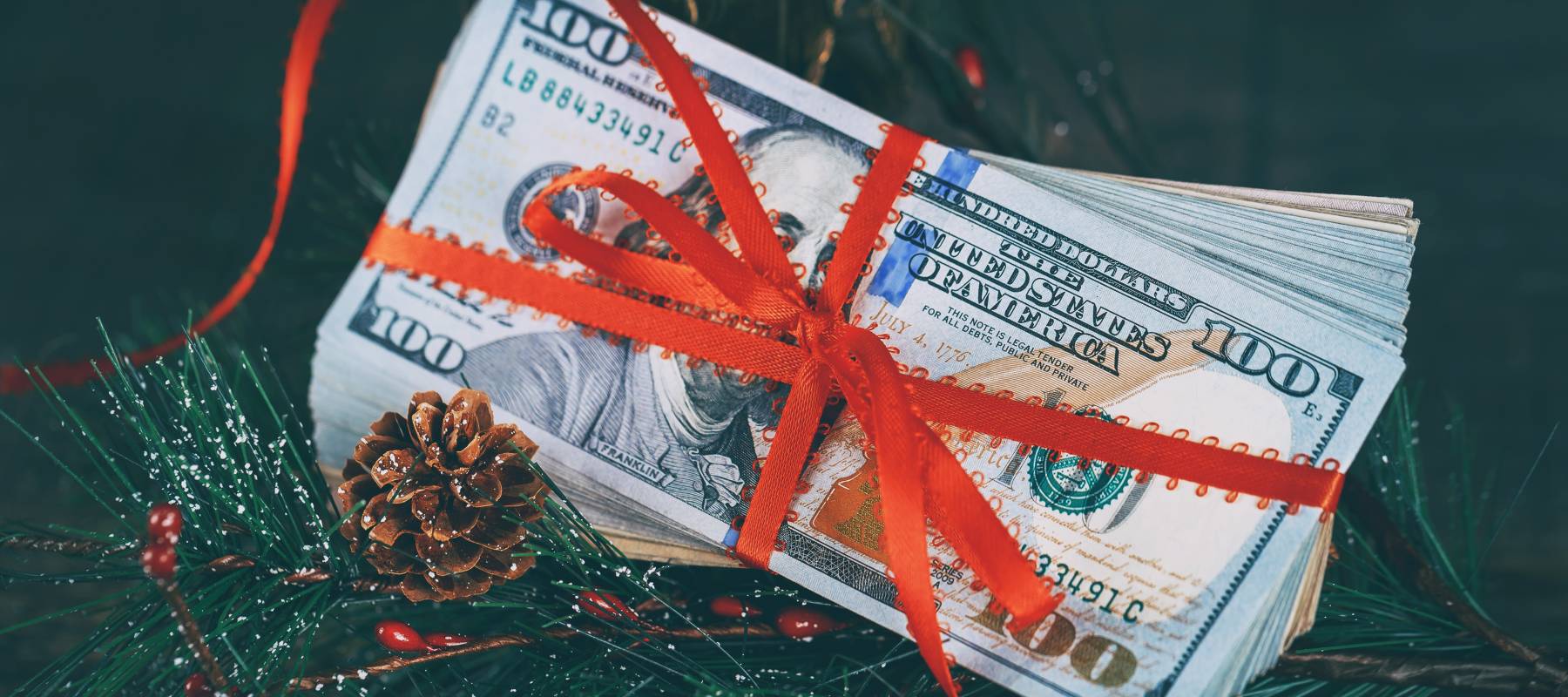 Money wrapped in a bow on the Christmas tree.
