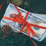 Money wrapped in a bow on the Christmas tree.