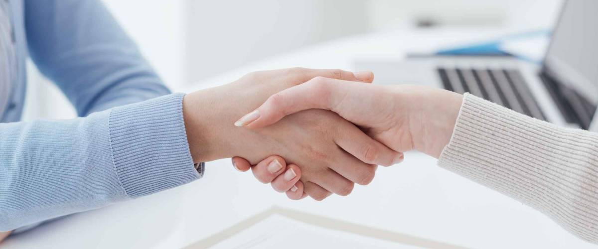 Real estate broker and customer shaking hands after signing a contract: real estate, home loan and insurance concept
