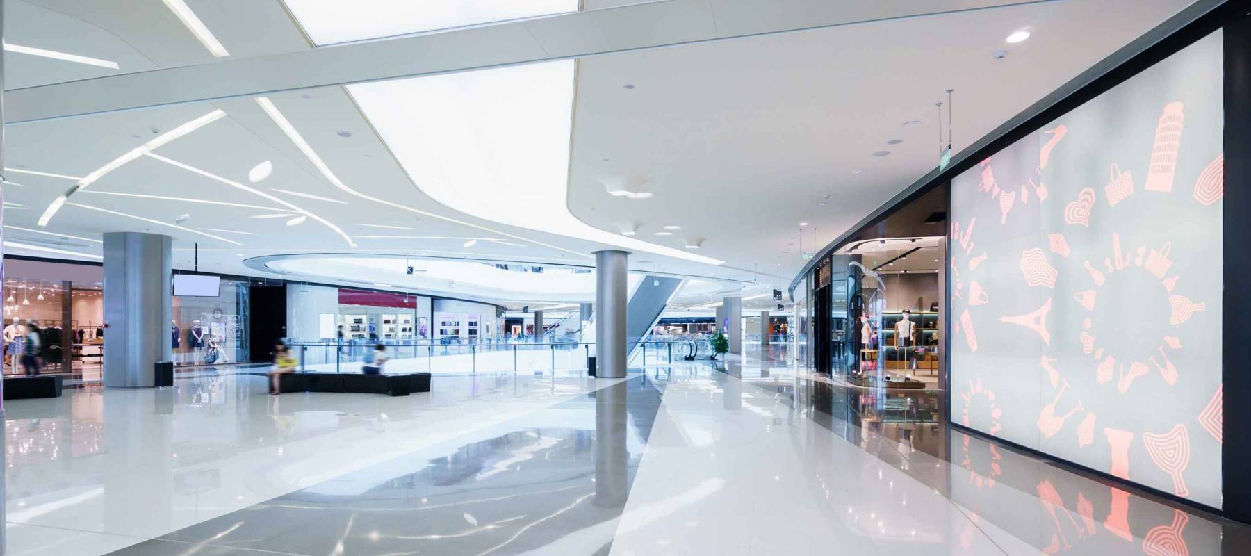 Empty hallway with a huge billboard and abstract ceiling in modern shopping mall