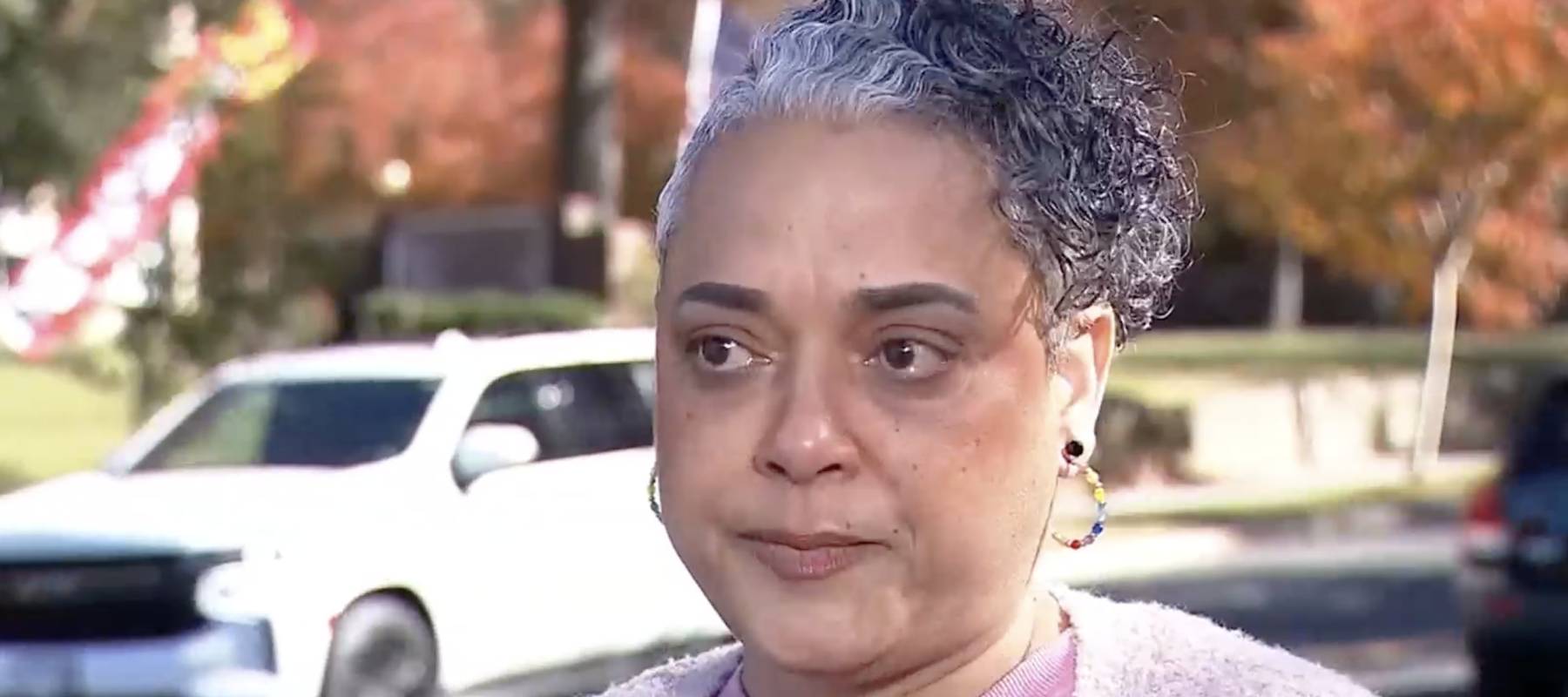 A woman looks emotional talking about unsafe living conditions in her rental complex.