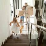 Happy children going upstairs inside two story big house,