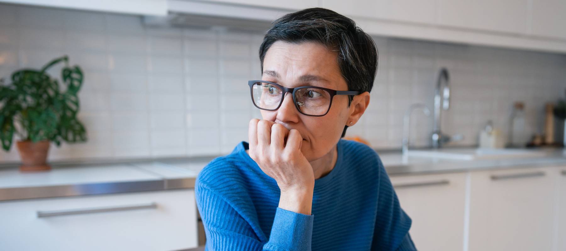 Stressed mature woman surrounded by bills and receipts, struggle with financial planning and debts.