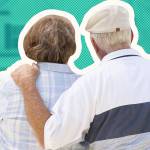 A headshot of a happy elderly couple standing in front of a house