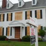 House for sale with boarded up windows.