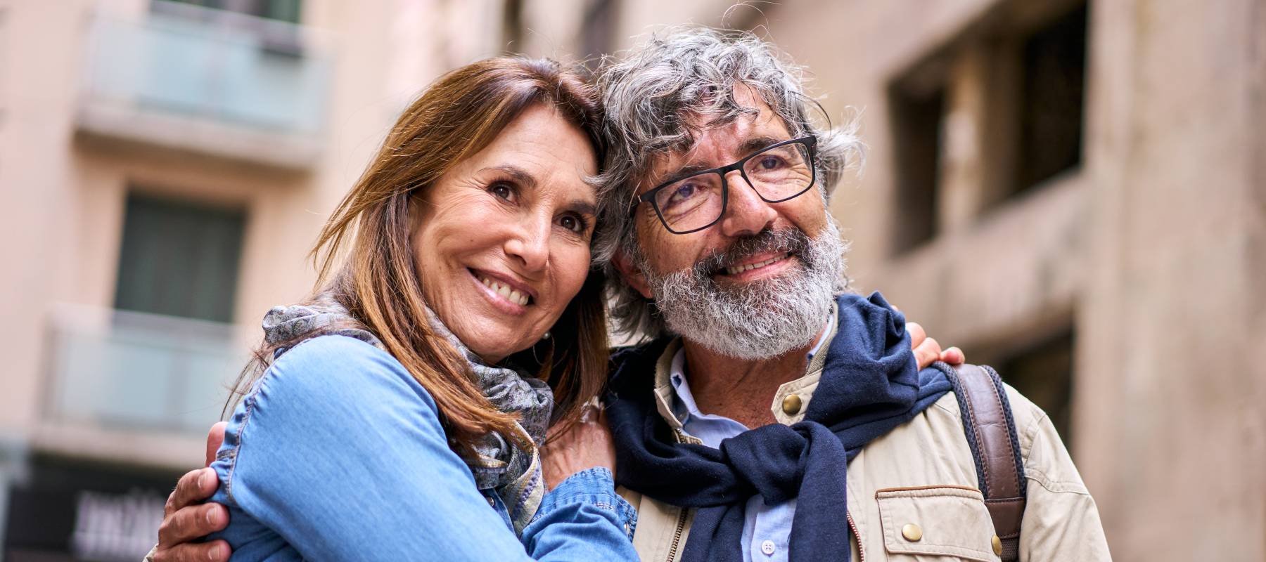 Retired happy couple looking out at a beautiful vista during a trip to a possible European destination, such as Italy.