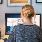 Woman working at her home computer, shot from behind
