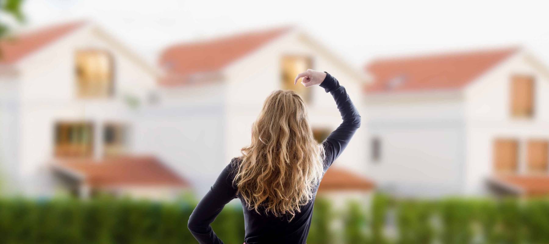 woman with an expression of doubt before the houses, buy house