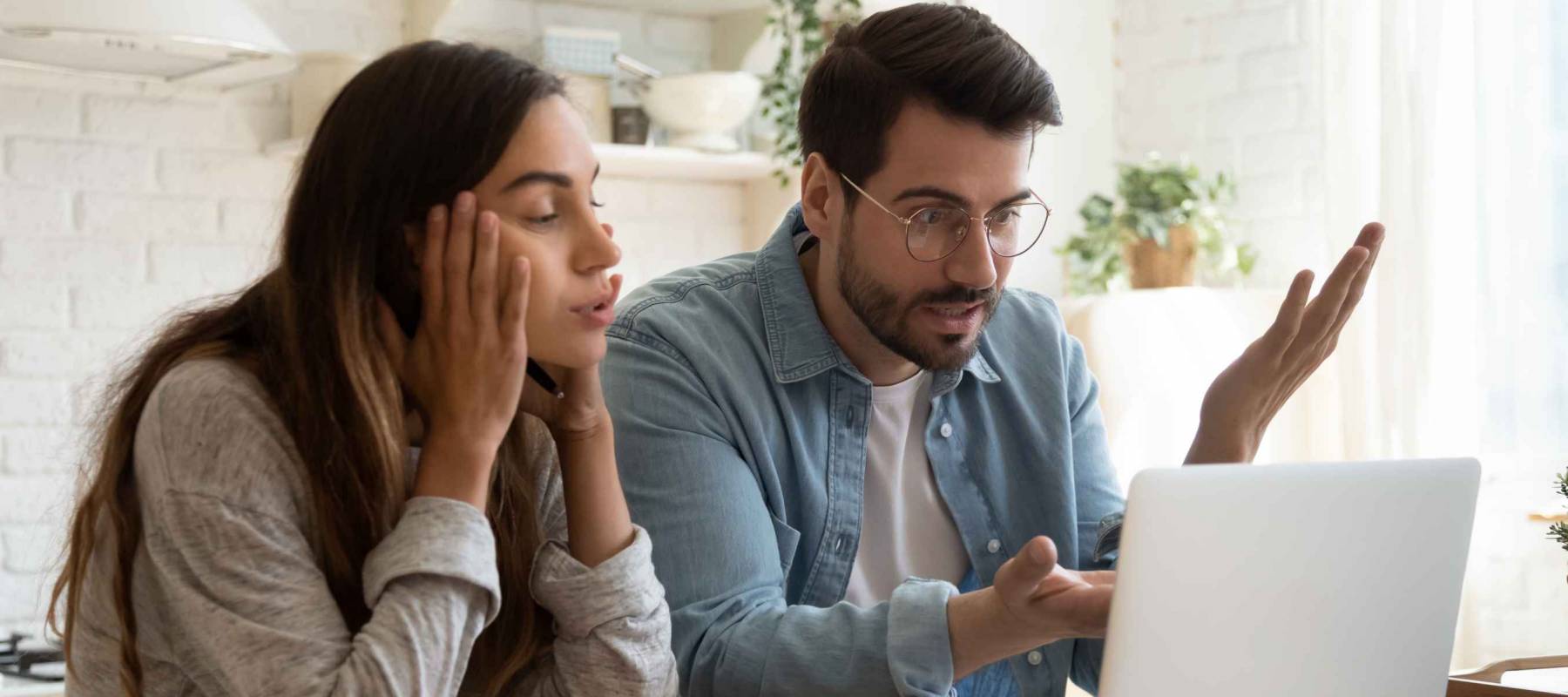 Frustrated young couple looking at laptop