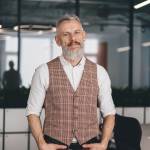 confident Caucasian middle-aged man standing in office room
